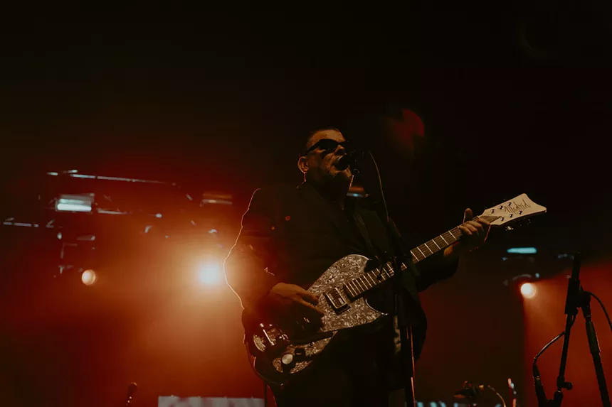A photo of The Black Heart Procession performing on stage.