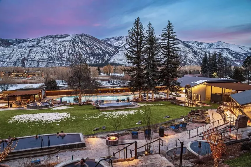 Durango Hot Springs' pools backdropped by snowy mountains at sunset