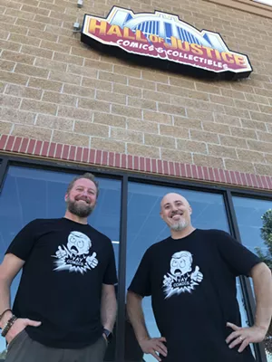 men smiling outside a comic store