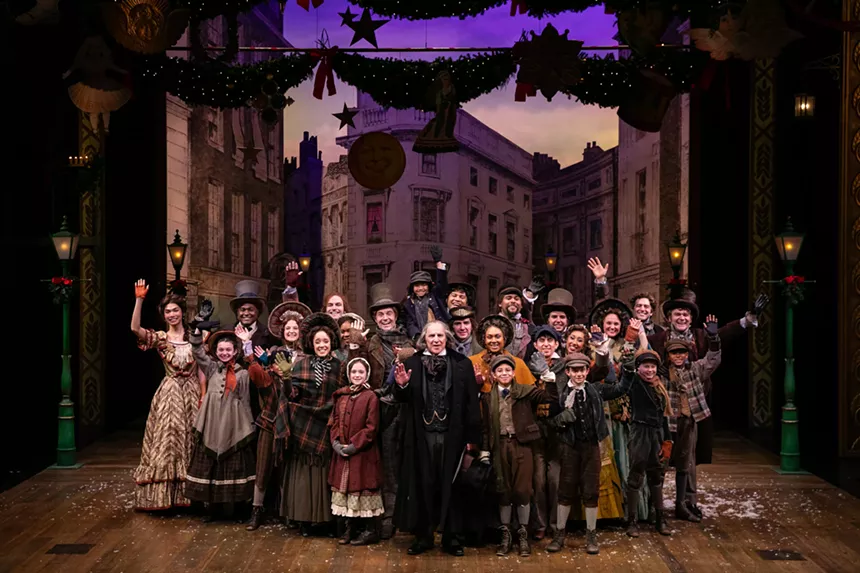 The cast of A Christmas Carol stands and waves center stage.