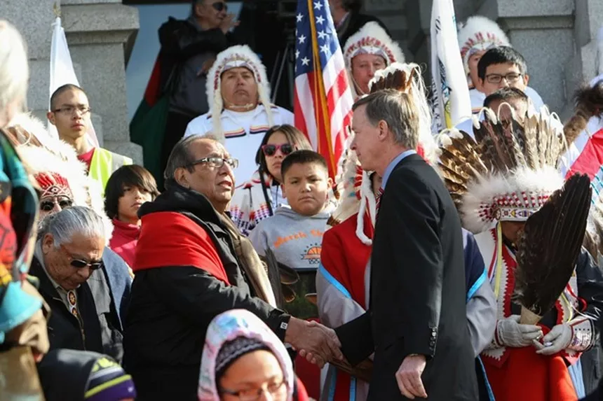 man in suit speaking to Natives