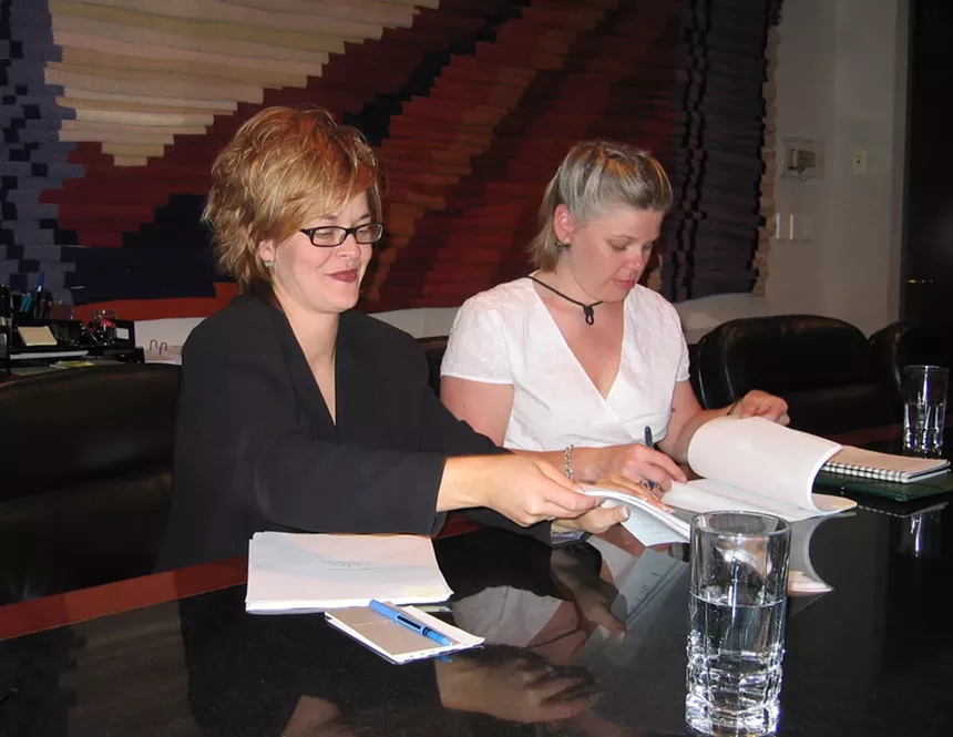two women signing papers