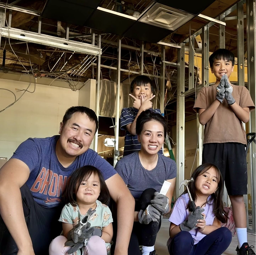 family posing for a photo holding tools