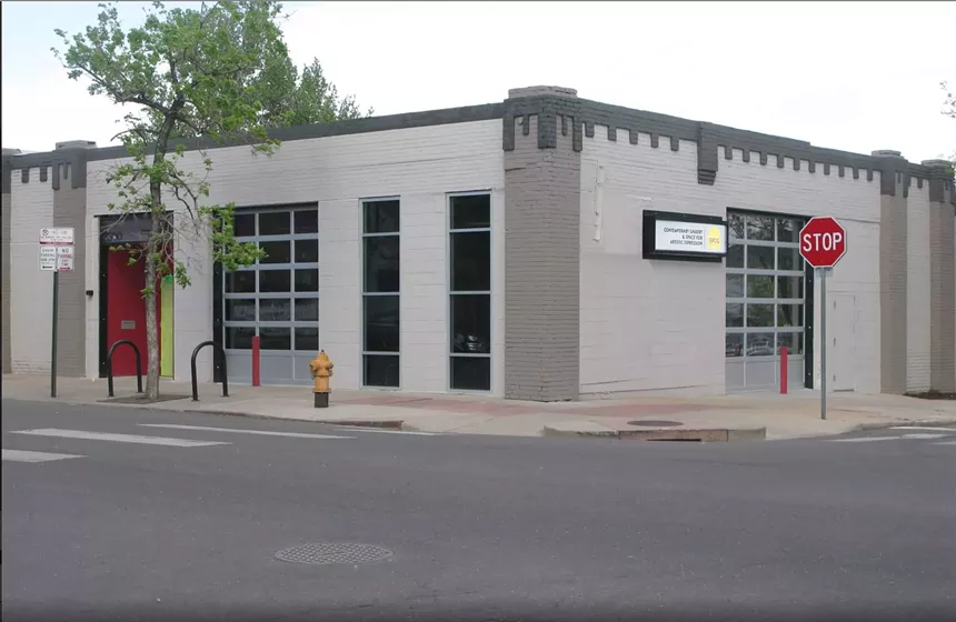 Exterior of a grey building near a stop sign