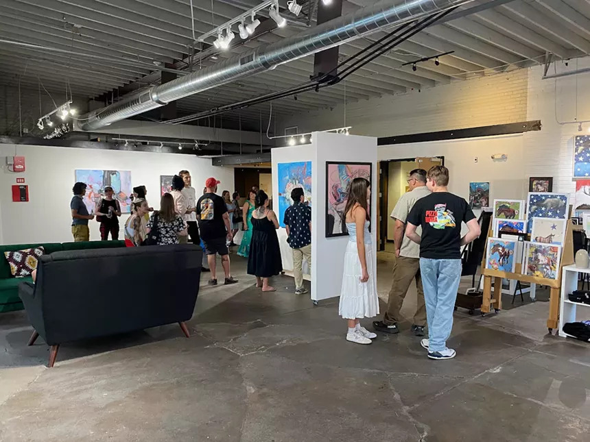 Interior of a crowded art gallery.