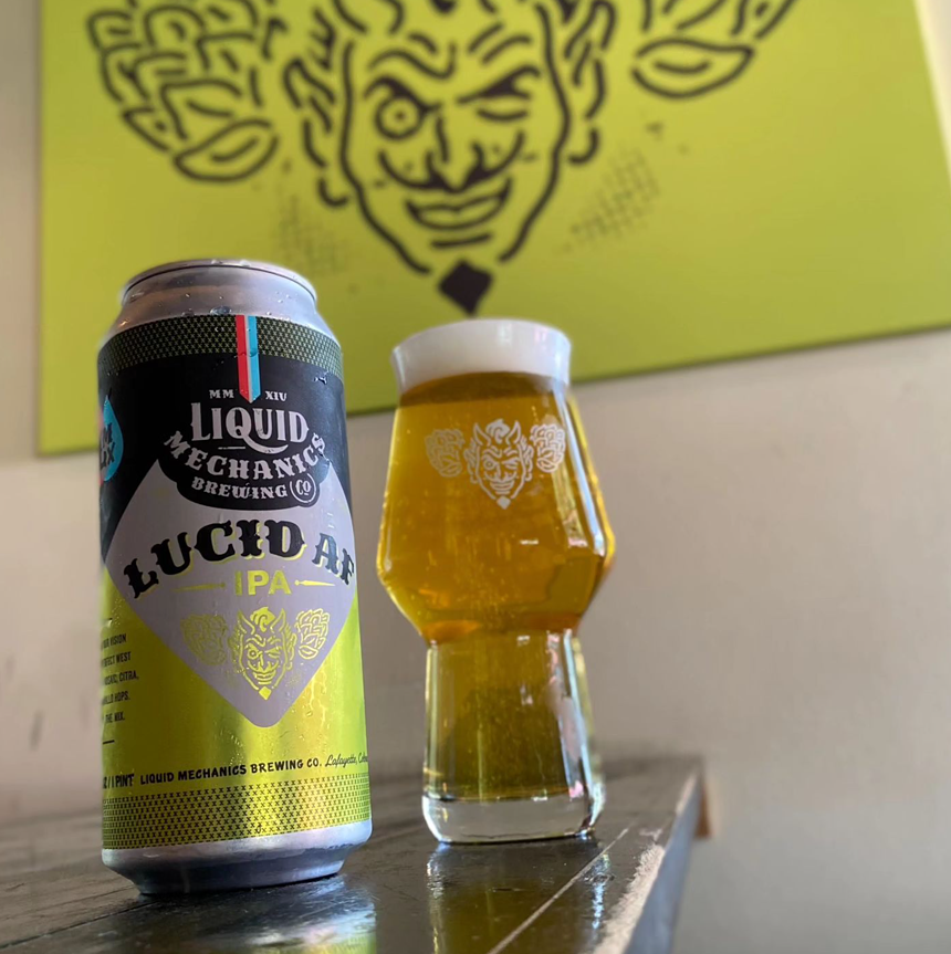 Beer in glass next to can.