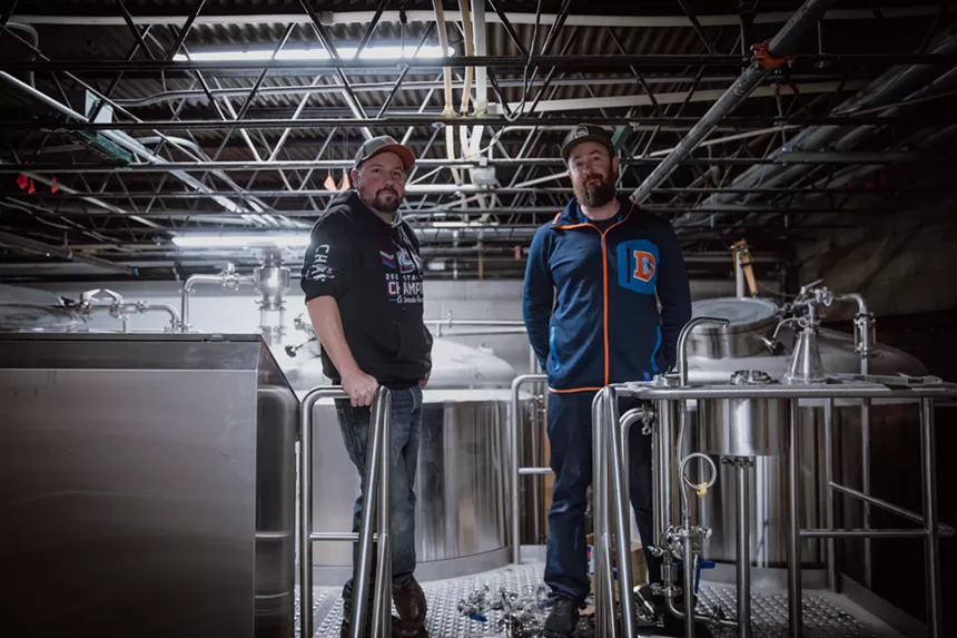 Two brewers standing on a brewery deck.