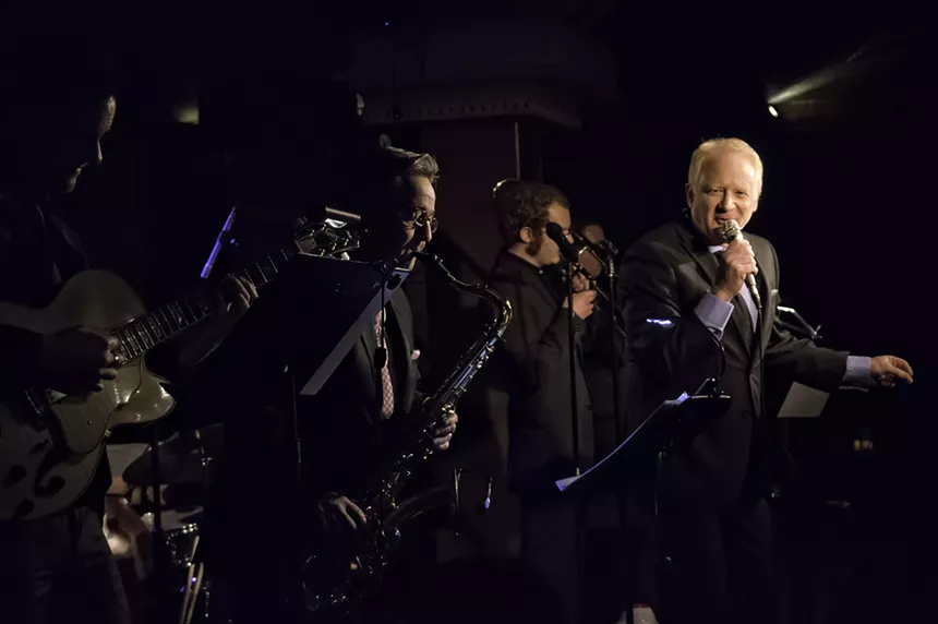 Man sings with band.