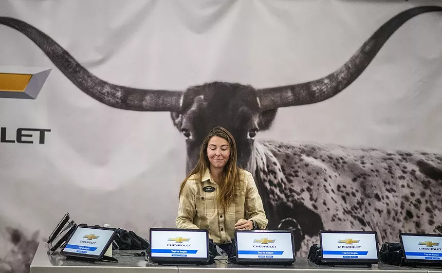 woman in front of longhorn poster