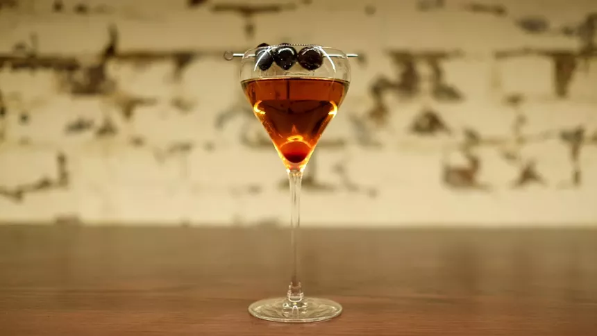 a cocktail garnished with cherries