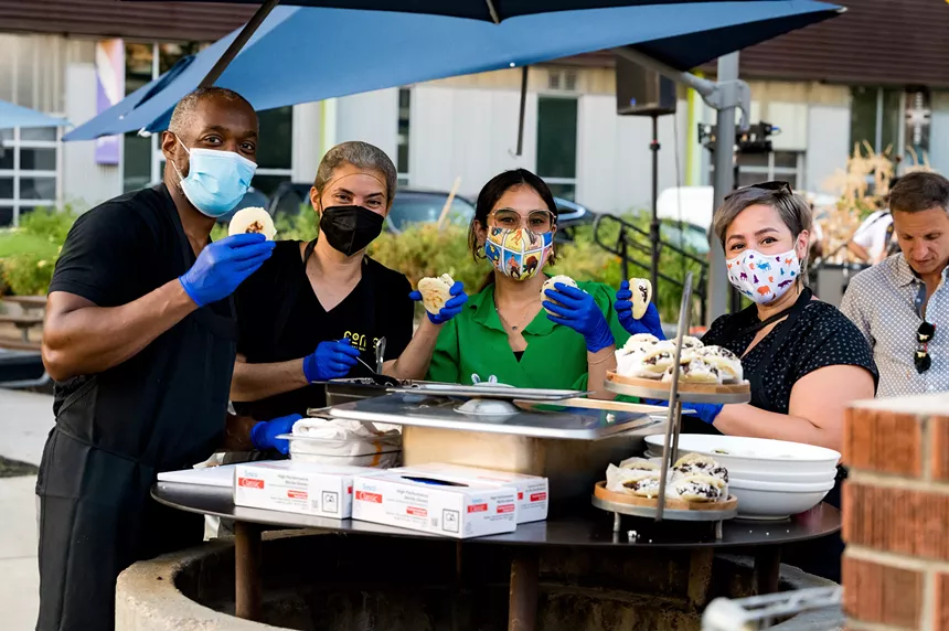 people wearing face masks and holding food