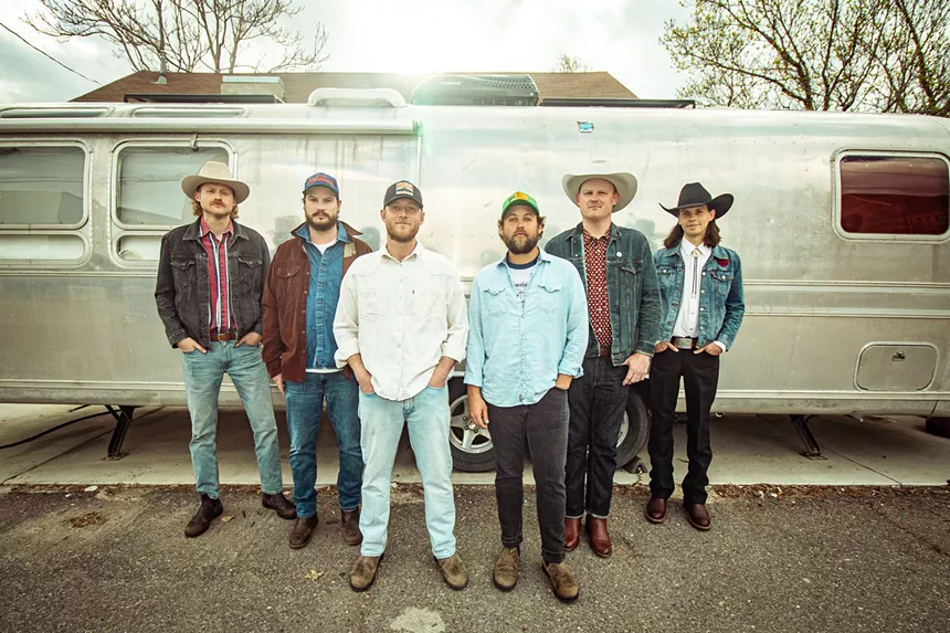 six men in front og truck
