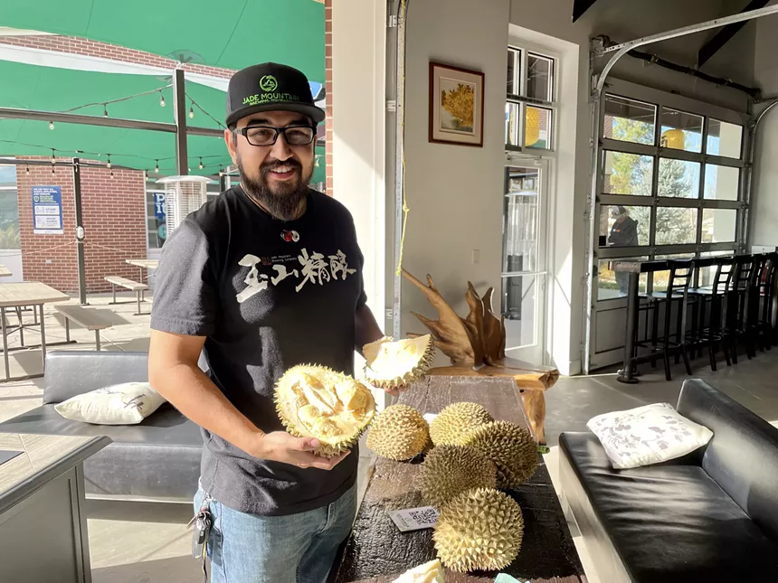 man holding durian fruit
