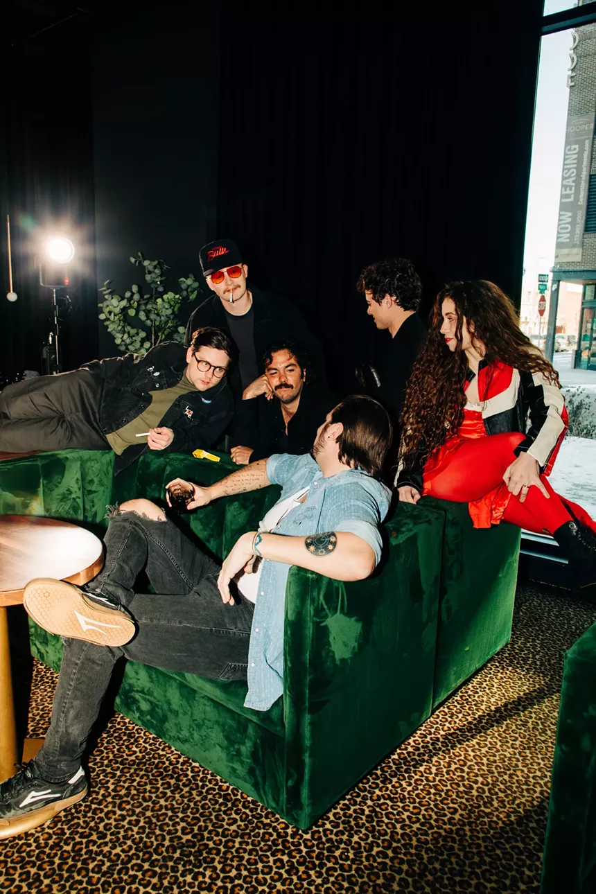 bandmates pose on a green couch