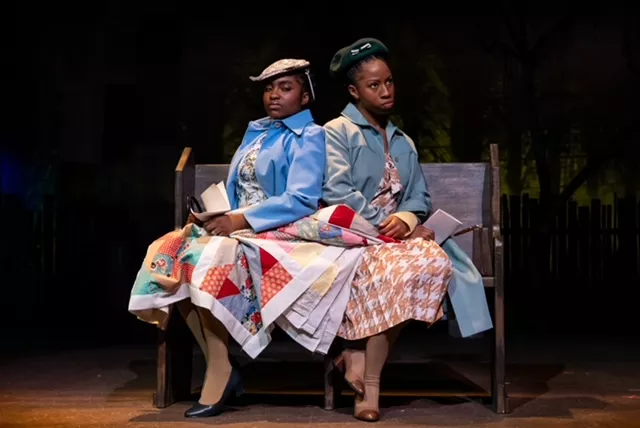 Two women sit beside each other on a bench.