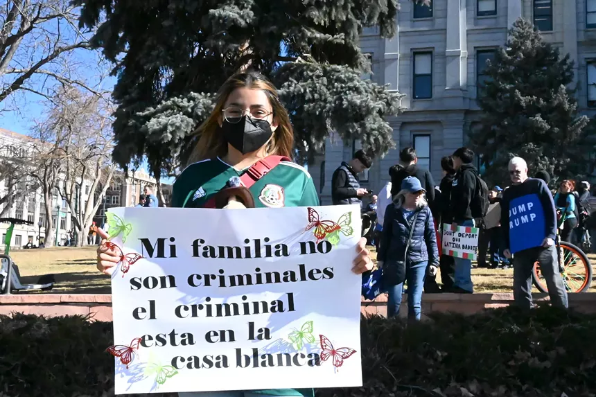 A woman holds a sign.