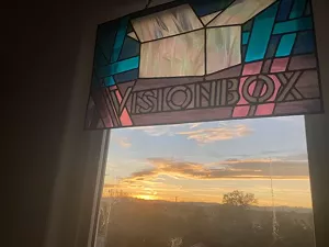 Sunlight hits stainglass that reads "Visionbox."