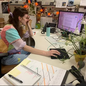 A person sits at a desk with a computer