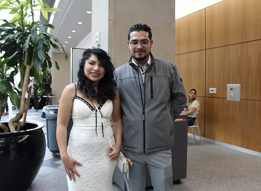 A bride and groom stand next to each other