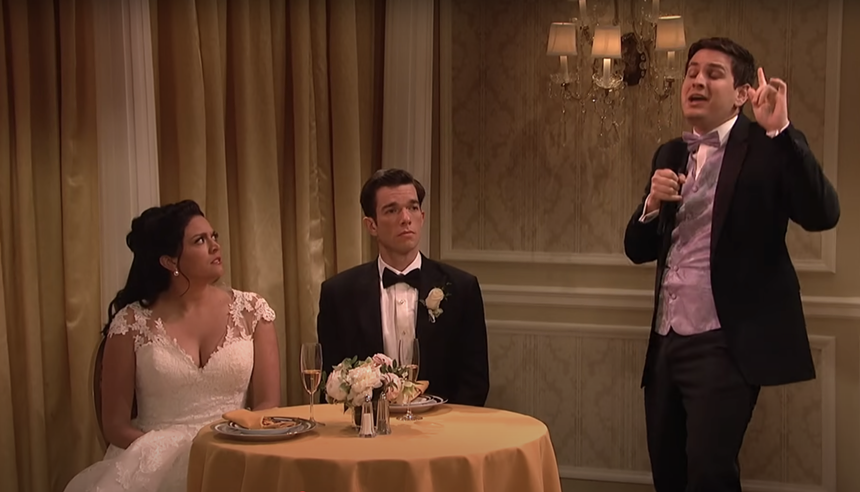 A man gives a speech to a bride and groom