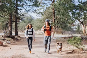 A man and woman walk with a dog