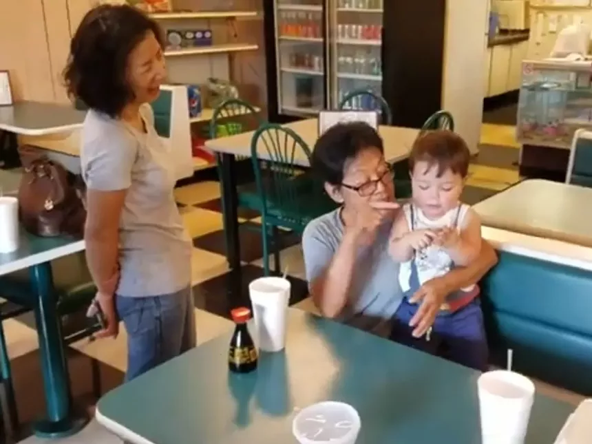 two women feeding child