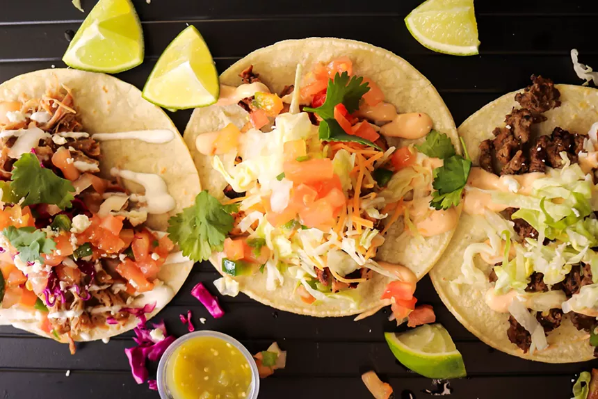 A trio of tacos, carnitas (left), chipotle chicken and carne asada.