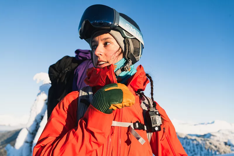 A woman in ski gear stands on a mountain.