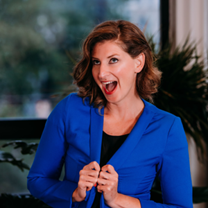 A woman poses wearing a blue jacket.