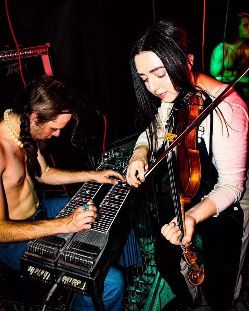 slide guitarist and fiddle player performing close together