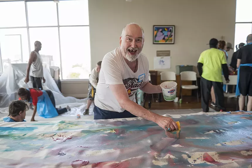 A man paints on a canvas