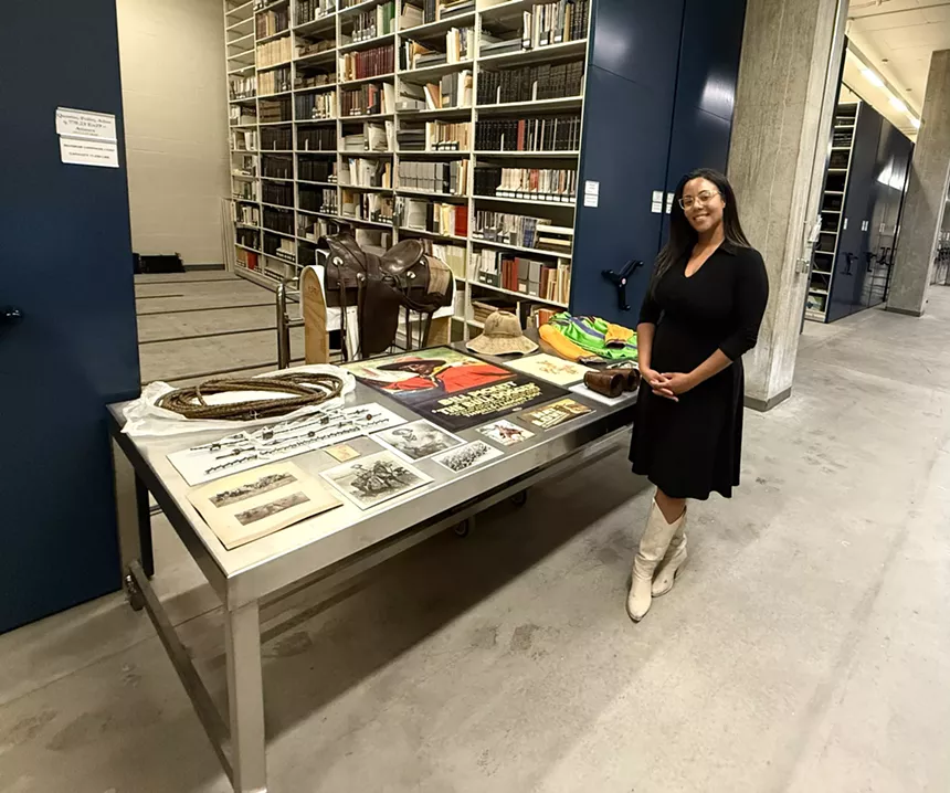 A woman stands next to a table