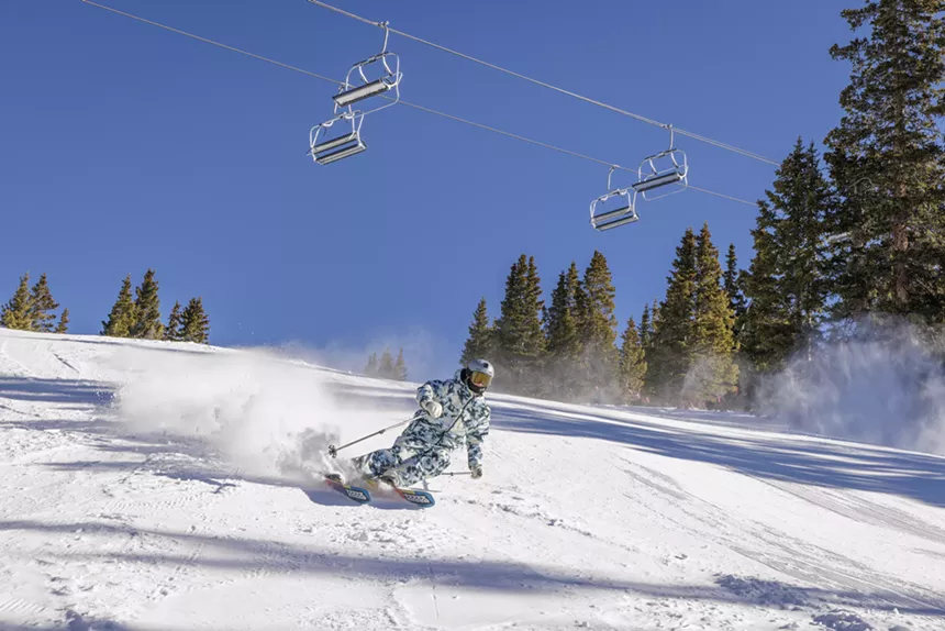 A skier backdropped by a chairlift at Arapahoe Basin
