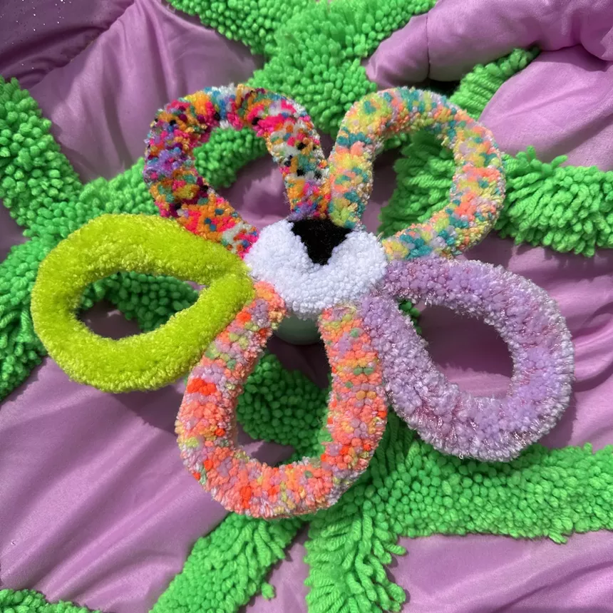 a flower with an eye in the middle made of yarn