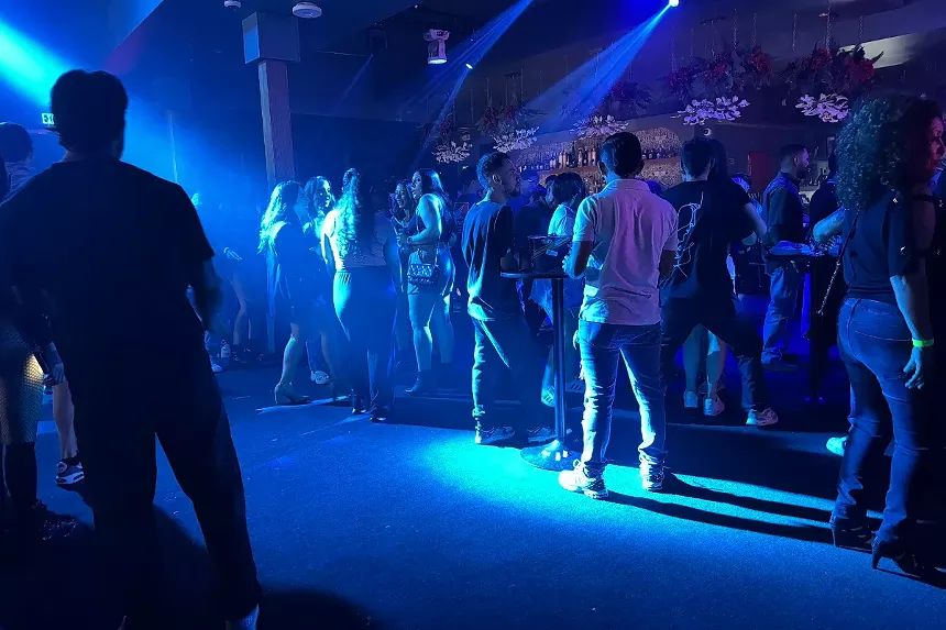 People stand on a dance floor.