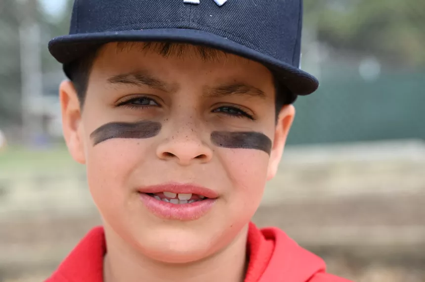 A boy with eye paint stares.