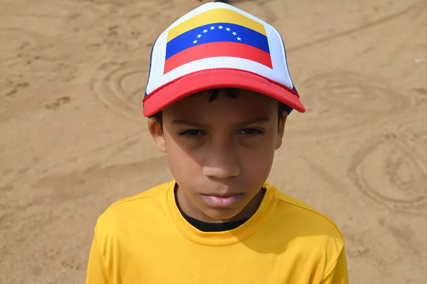 A boy with a Venezuelan hat stares.