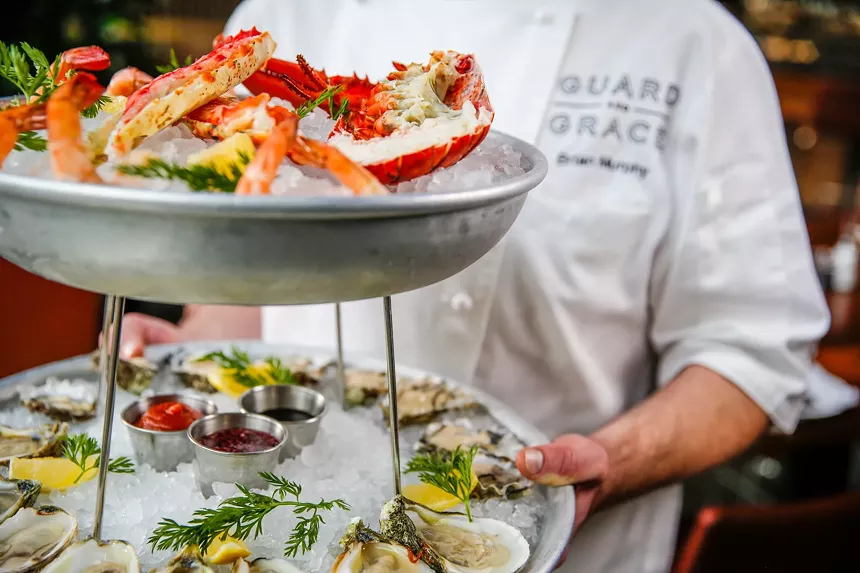 A chef from Guard and Grace holding a fresh seafood tower