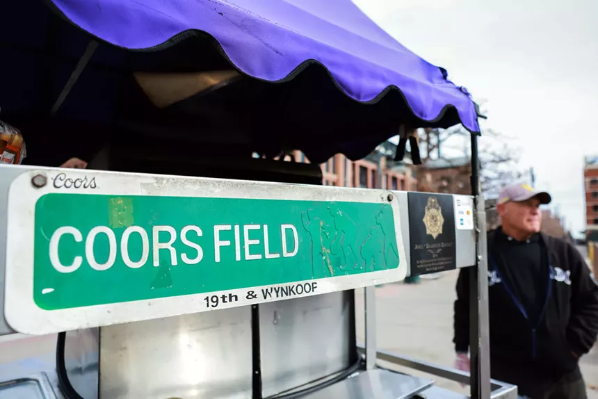 "coors field" street sign on a hot dog cart
