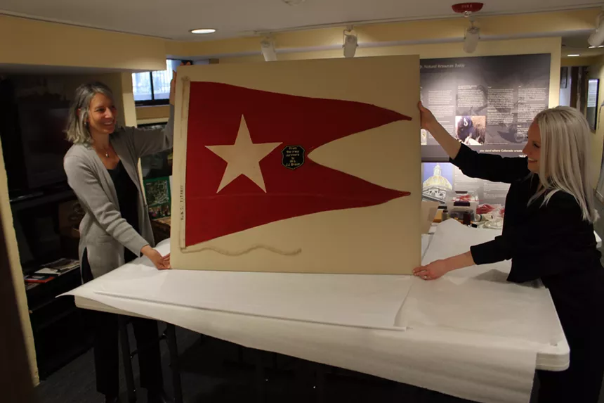 two people holding up a flag