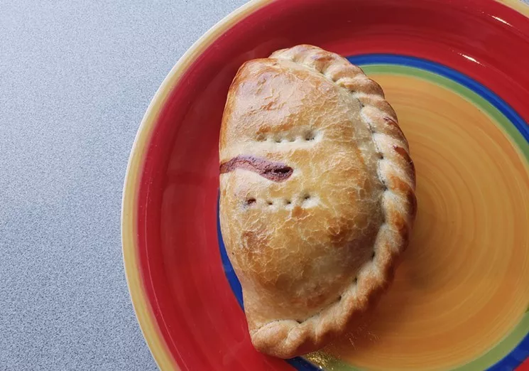 a stuffed pastry on a colorful plate