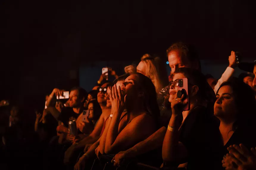 A photo of concertgoers dancing.