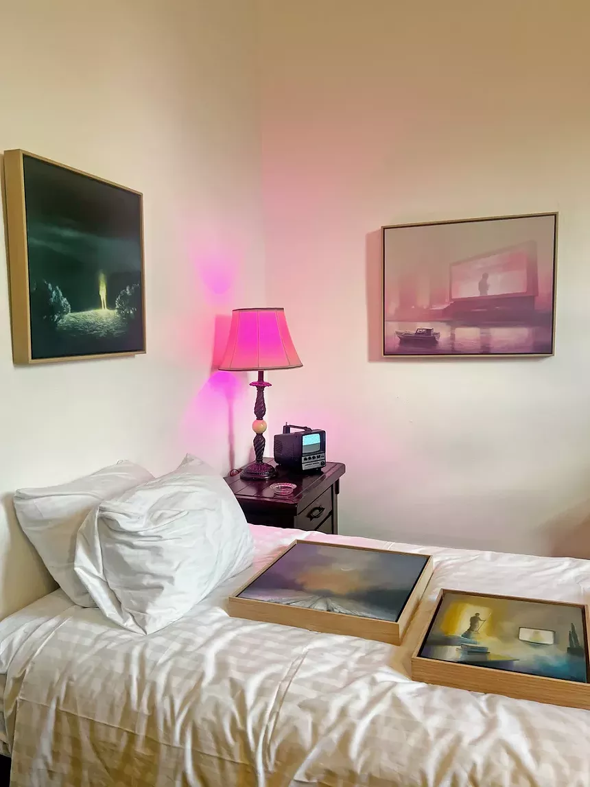 A pink lamp by a bed