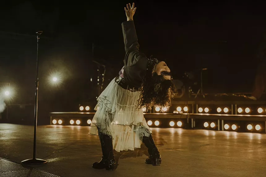 A picture of Remi Wolf bending backward on stage at Red Rocks.