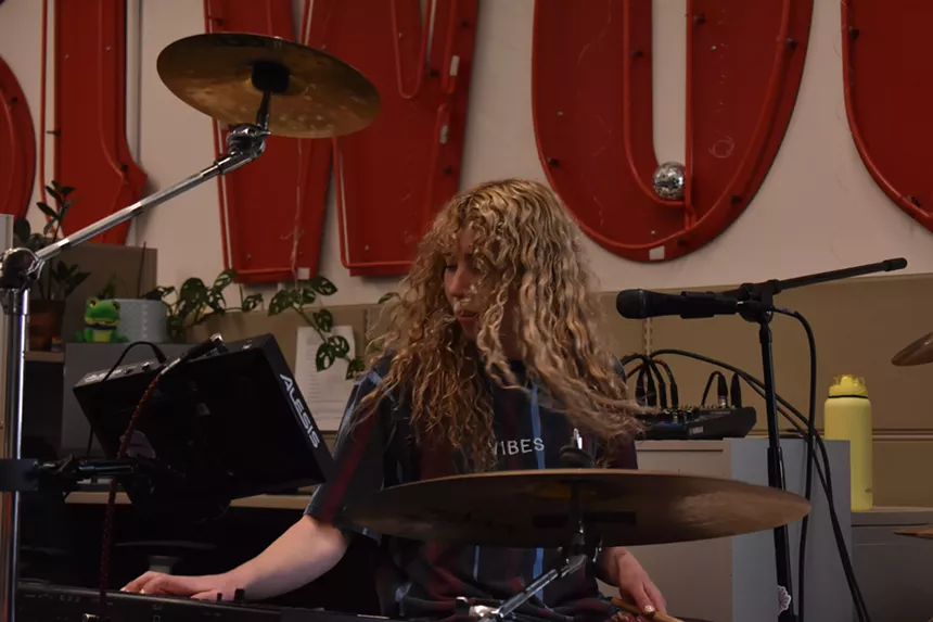 blonde woman playing drums and keys