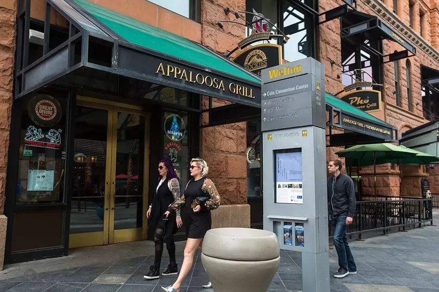 People walking on the outside building face of Appaloosa Grill, with the front sign in the background