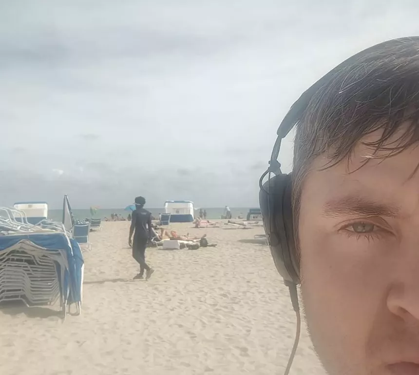 man on beach with headphones