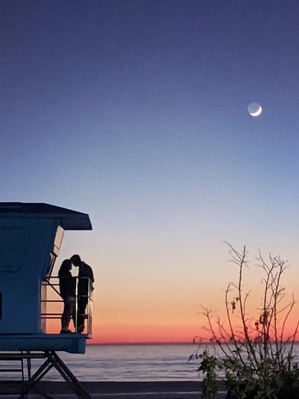 A photograph of two people at twilight.