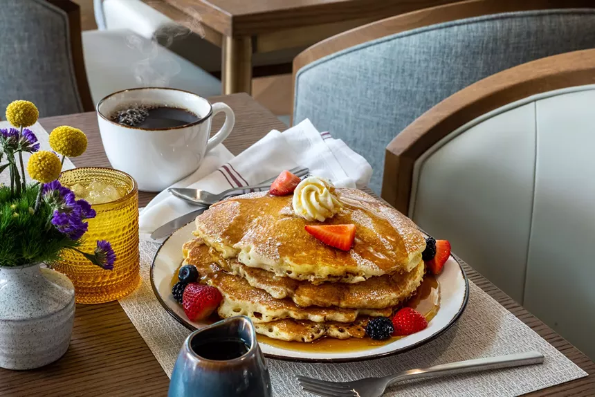 A stack of pancakes and cup of coffee from The Common Good