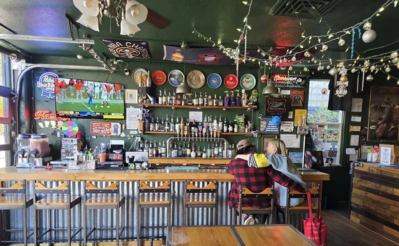 Retro bric-a-brac on a green wall at TrashHawk Tavern